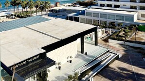 A resort with a pool, palm trees, and a view of the ocean. - Constantinos The Great Beach Hotel (Paralimni)