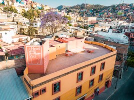 Una terraza en la azotea de un hotel, rodeada de edificios de colores.