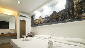 A hotel room with a bed, a bathroom, and a large window with a view of a historic building. - New Town Hotel Sunway Metro, Bandar Sunway (Petaling Jaya)