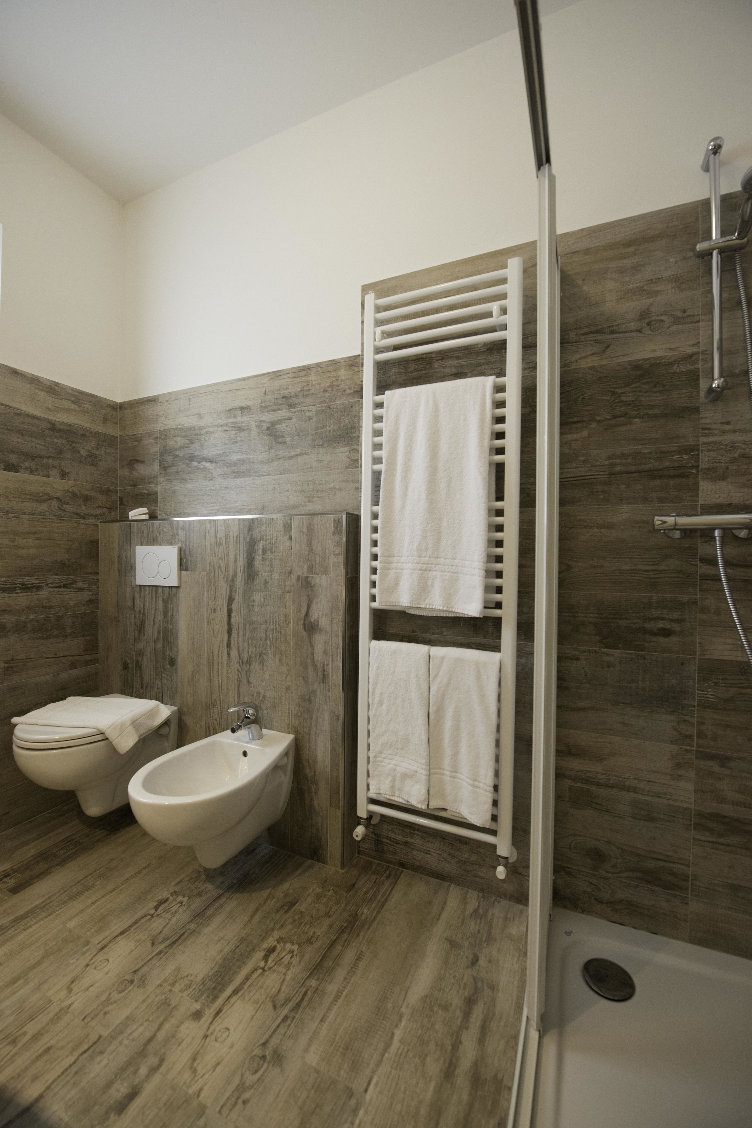 Un baño moderno con un bidé, un inodoro y una ducha.