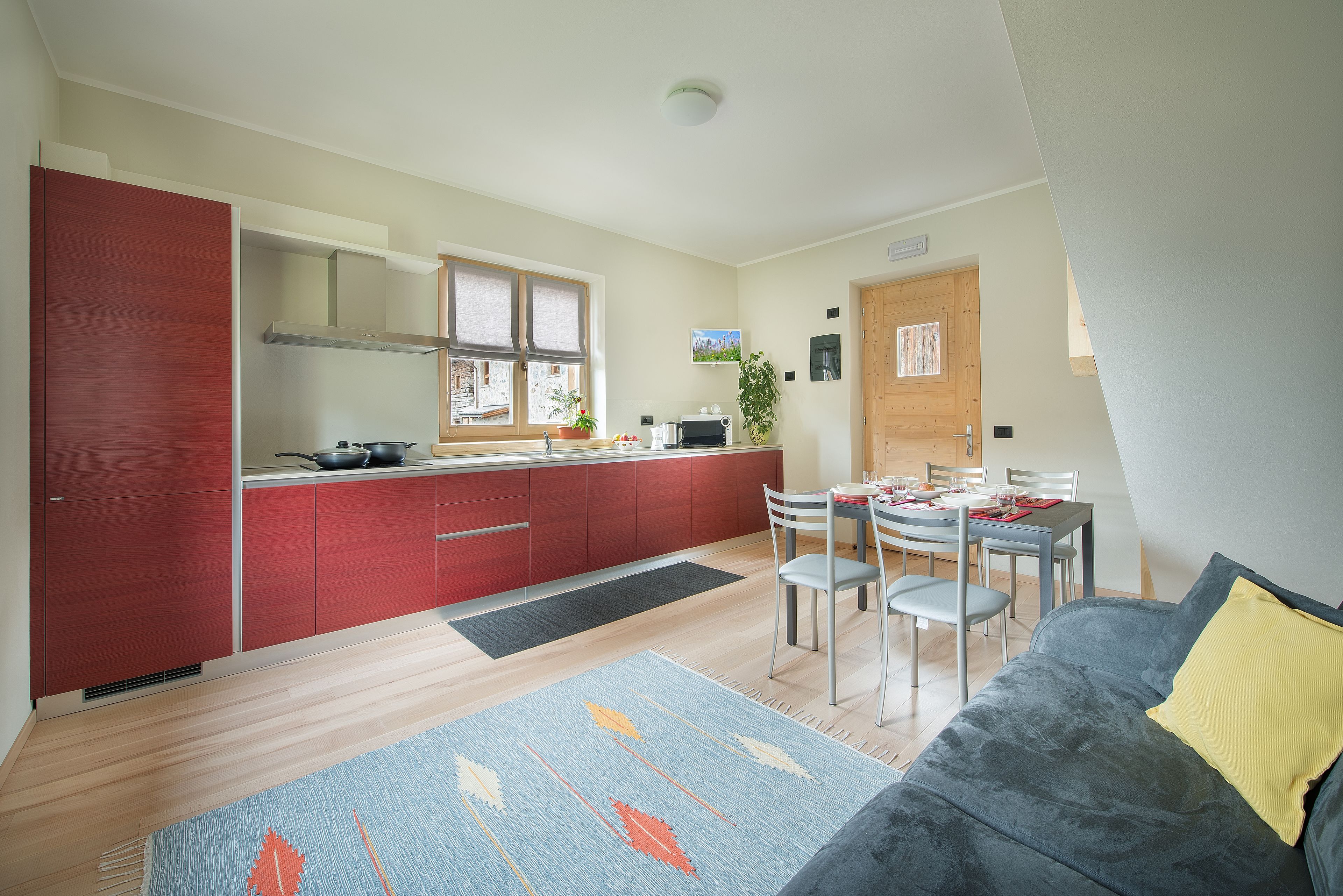A compact living space with a kitchenette, dining area, and a sofa.