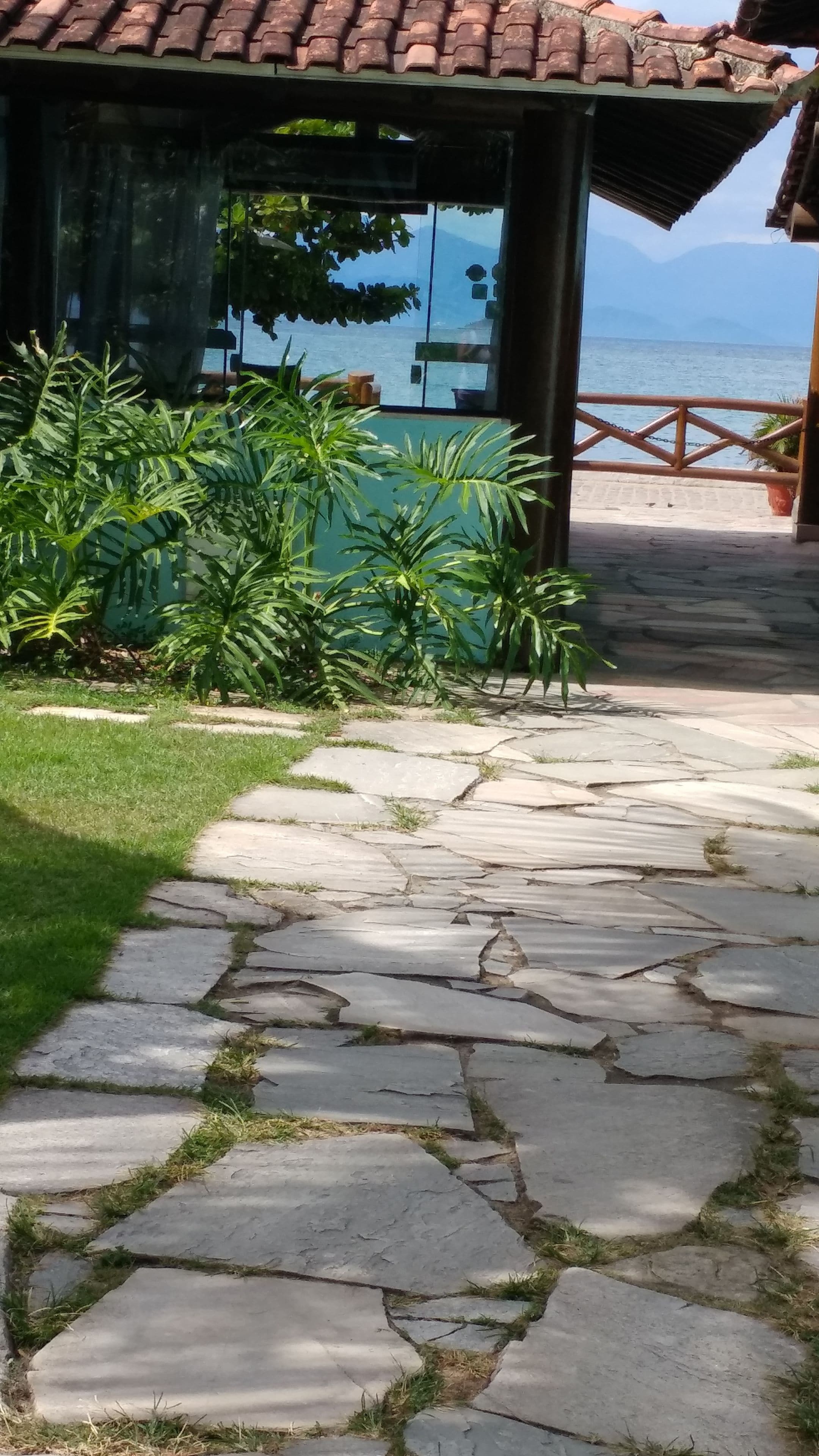 Un sentiero in pietra conduce a una zona riparata con vista sul mare.