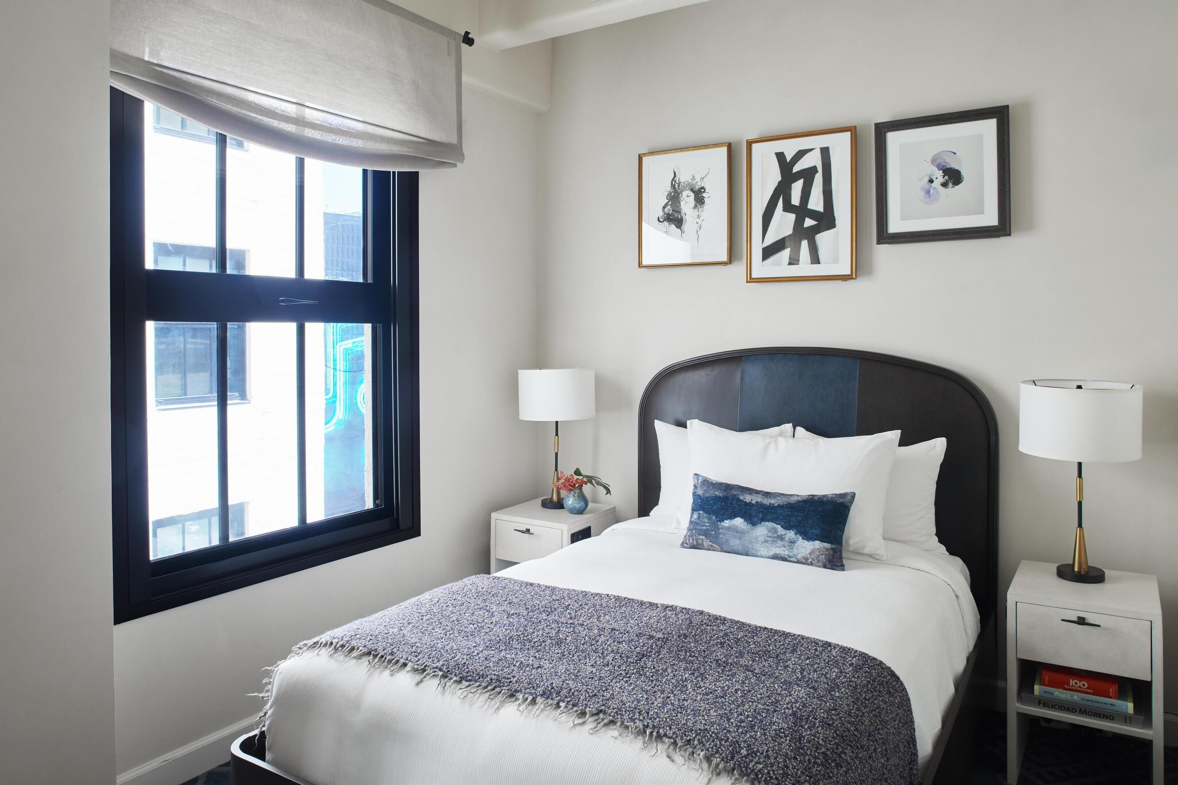 A neatly arranged bedroom with a bed, bedside tables, and a window.