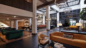 A spacious lobby with high ceilings, large windows, and modern lighting fixtures. - Hotel Figueroa, Unbound Collection by Hyatt (Los Angeles)