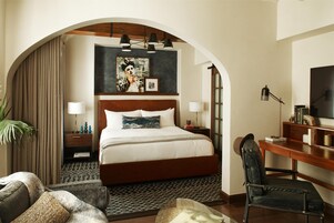 Una camera d'albergo con un letto grande, una scrivania, una sedia e una televisione.