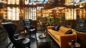 A modern lounge with leather chairs, a sofa, and a glass coffee table. - Hotel Figueroa, Unbound Collection by Hyatt (Los Angeles)