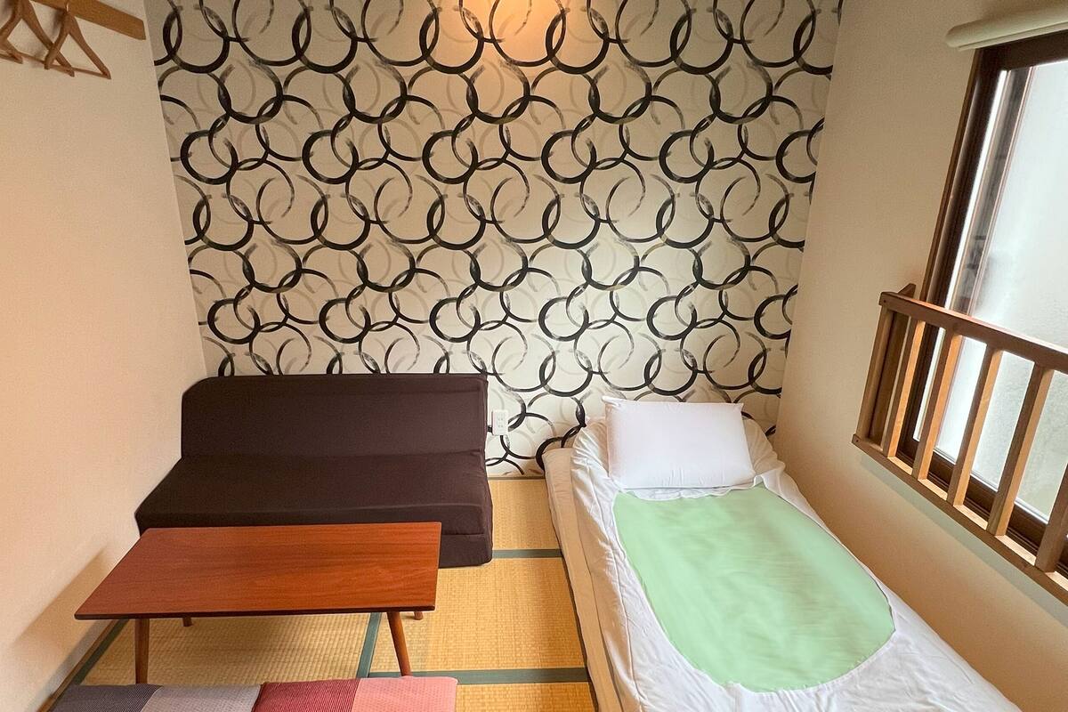 A small room with a bed, a sofa, and a small table.