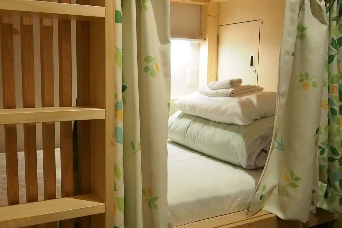 A room with a bunk bed, a small desk, and a door.