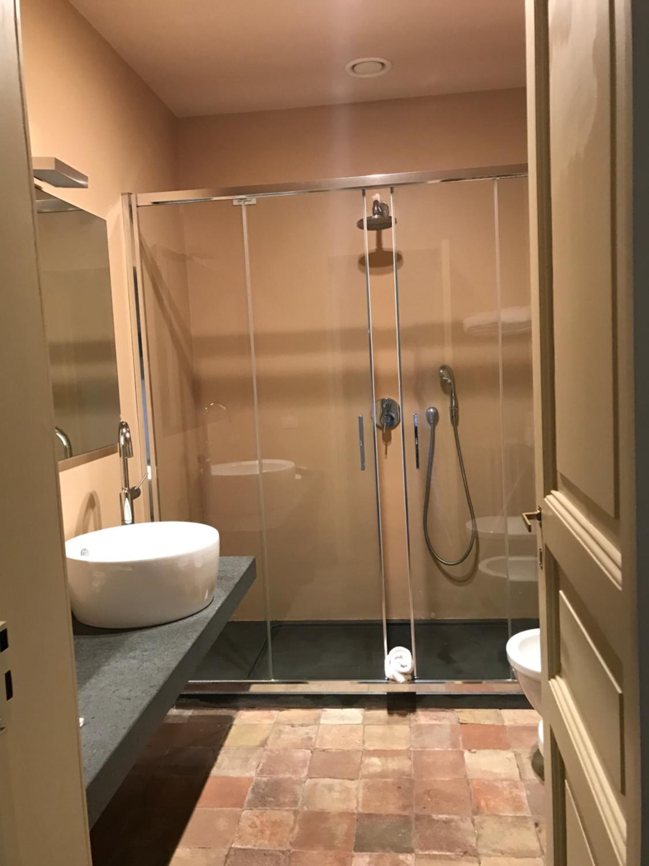 Une salle de bain moderne avec une douche à parois de verre, un lavabo blanc et des toilettes.