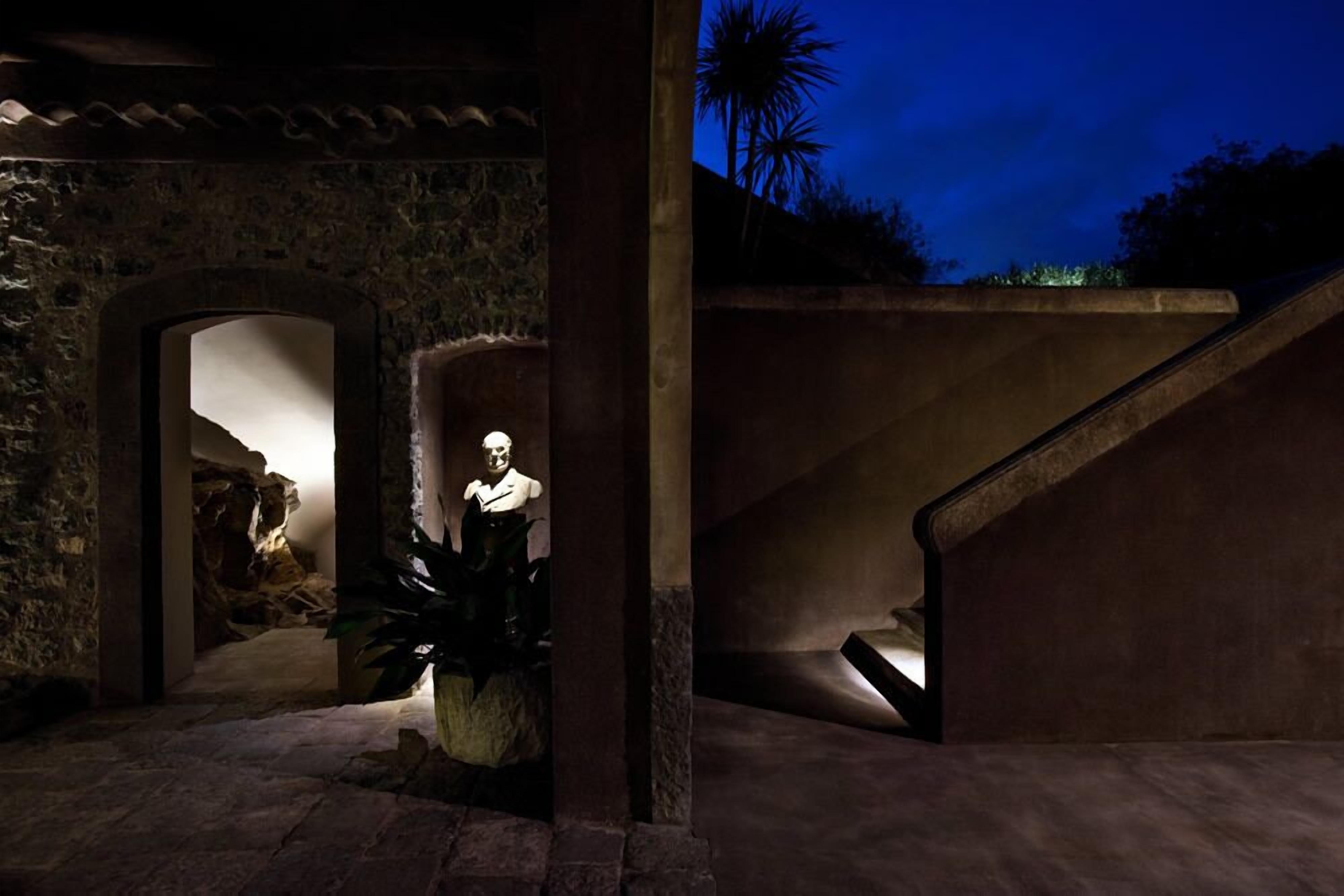 A stone building with a staircase and a statue.