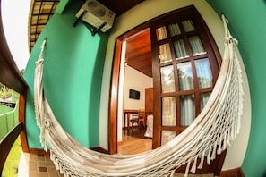 Relax in a cozy space with a hammock and dining area, complete with a ceiling fan for comfort.