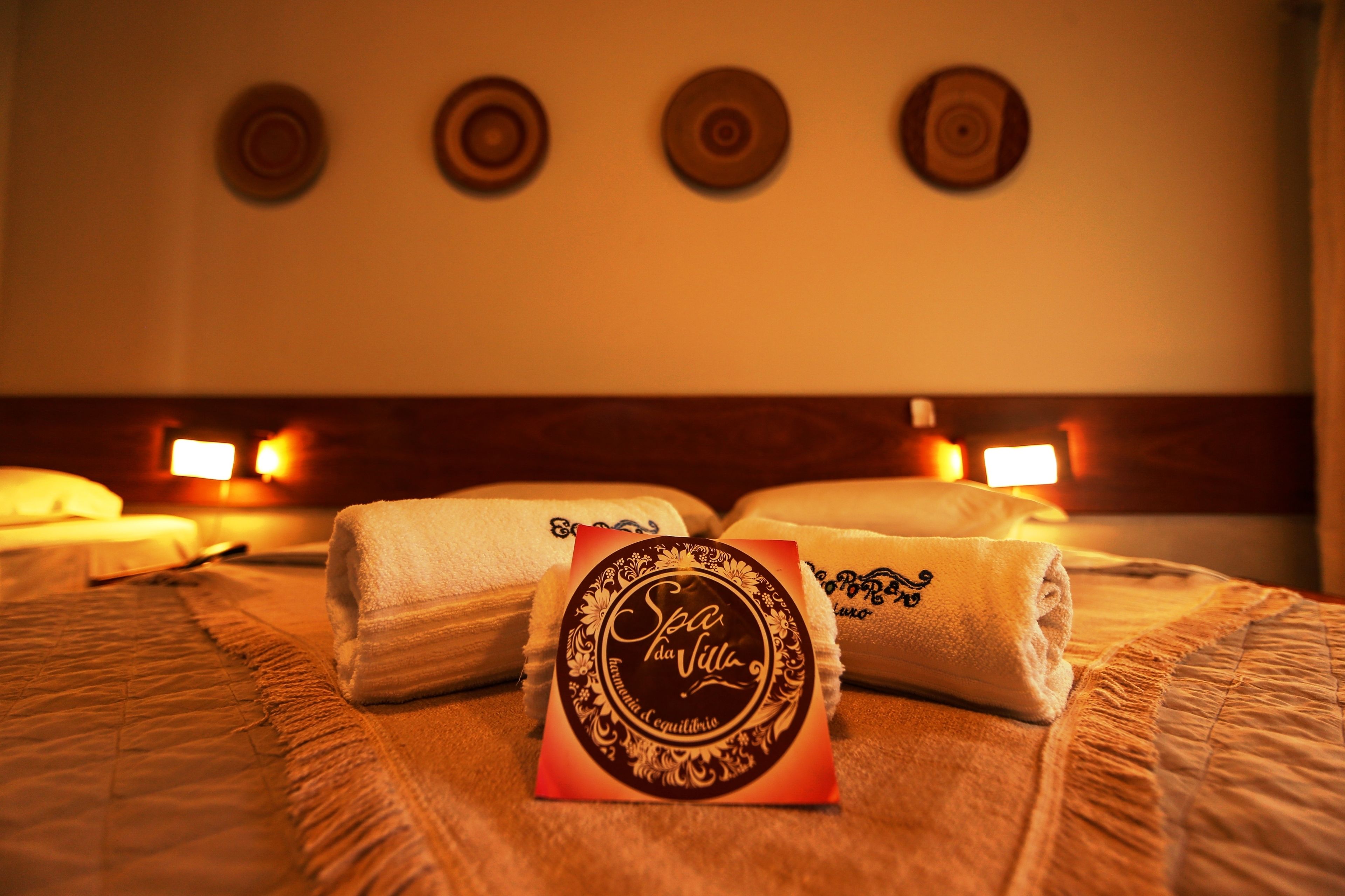 A neatly made bed with folded towels and a decorative card on the bed.