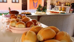 Een buffet met verschillende soorten eten, waaronder broodjes en gebak.