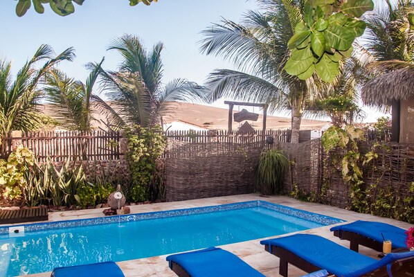 Una piscina al aire libre, tumbonas