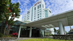 Un hotel moderno con una entrada destacada, amplios ventanales y un corredor cubierto.