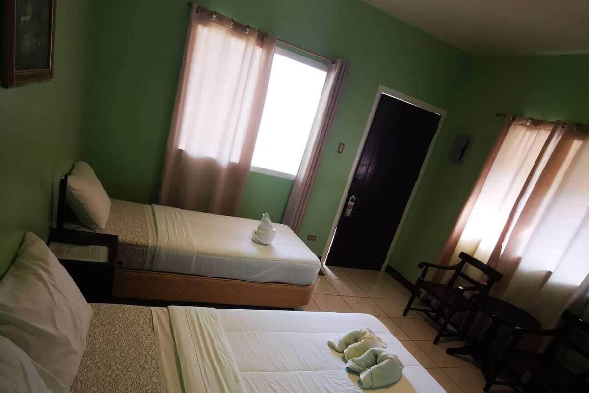 Ein Hotelzimmer mit zwei Betten, einem Schreibtisch und einem Stuhl.
