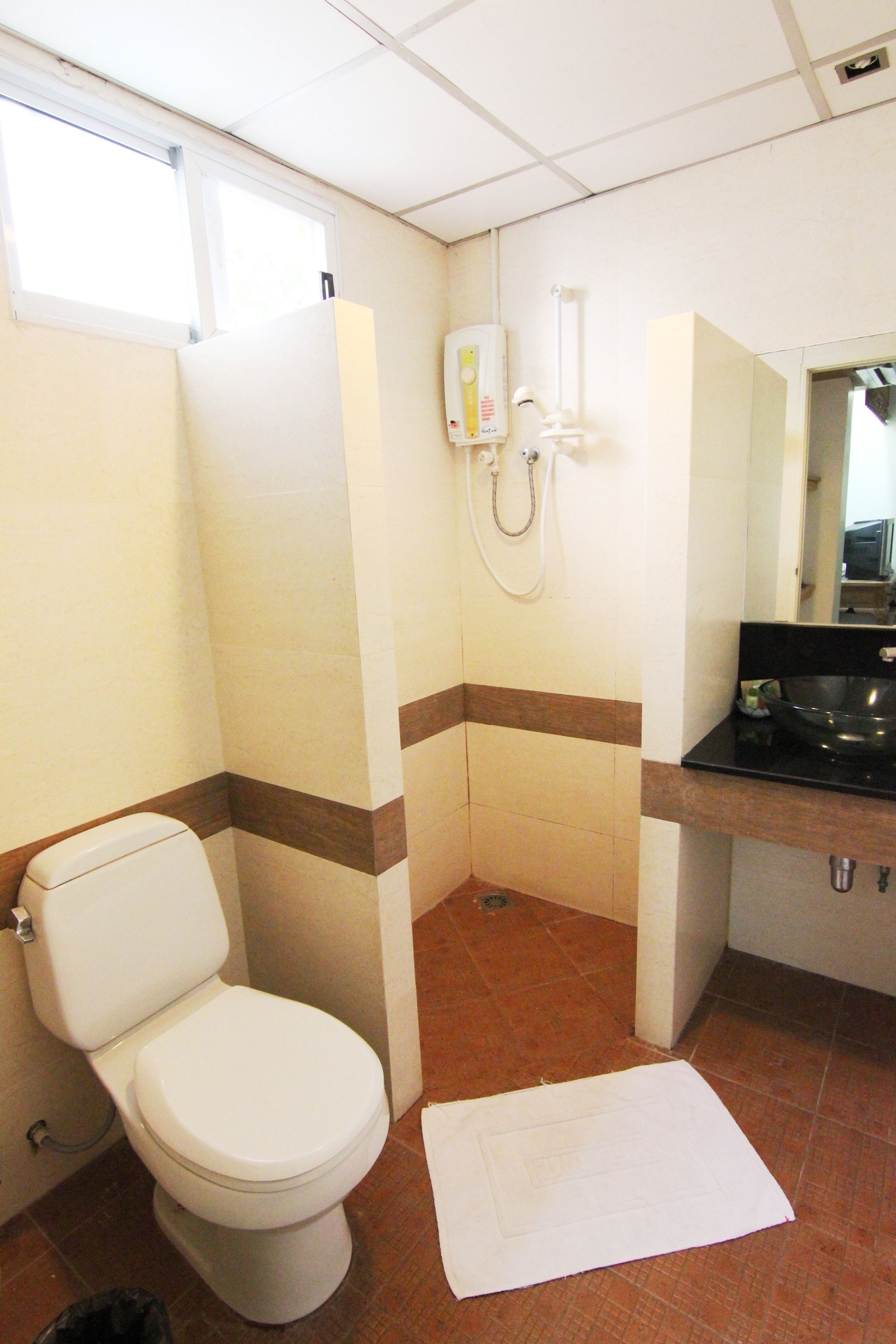 A bathroom with a toilet, a sink, and a mirror.