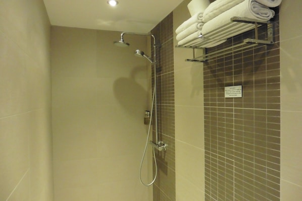 A shower with a handheld showerhead and a wall-mounted faucet. - Brighton Inn Boutique Guest Accommodation (Brighton)