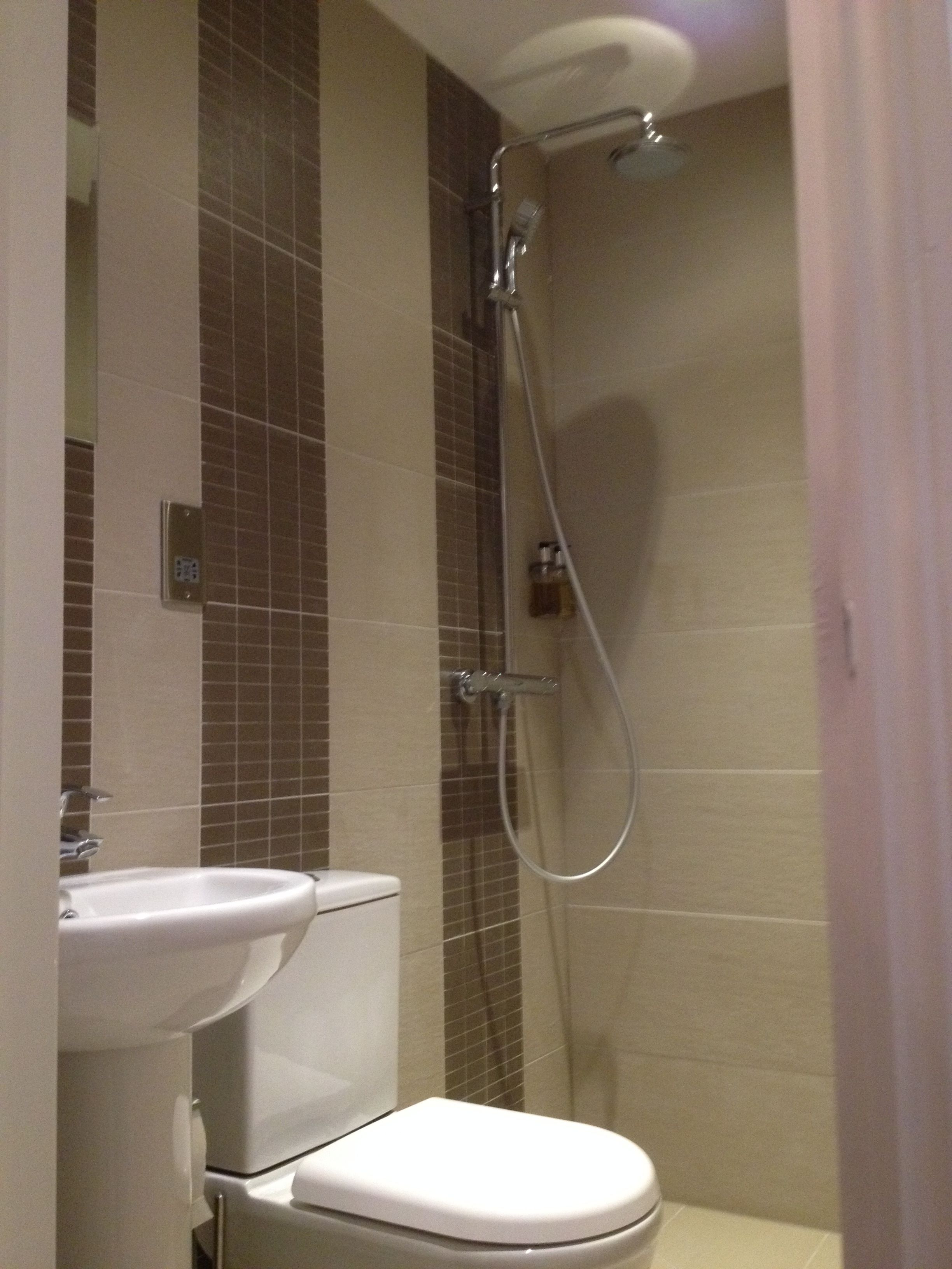 A bathroom with a toilet, sink, and shower.