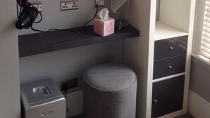 A bedroom with a bed, a desk with a computer monitor, a mirror, a small heater, and a wardrobe. - Brighton Inn Boutique Guest Accommodation (Brighton)