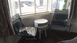 A room with a glass chair, a white stool, and a radiator. - Brighton Inn Boutique Guest Accommodation (Brighton)