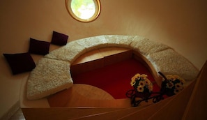 A curved staircase with a wooden handrail, a red carpet, and a small window at the top. - DNA Super Ozone Resort KhaoYai (Pak Chong)