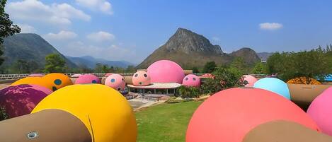Vista de un resort con estructuras esféricas de colores y montañas al fondo.