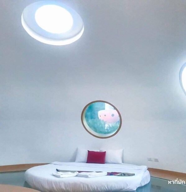 A modern hotel room with a bed, a circular window, and a skylight. - DNA Super Ozone Resort KhaoYai (Pak Chong)