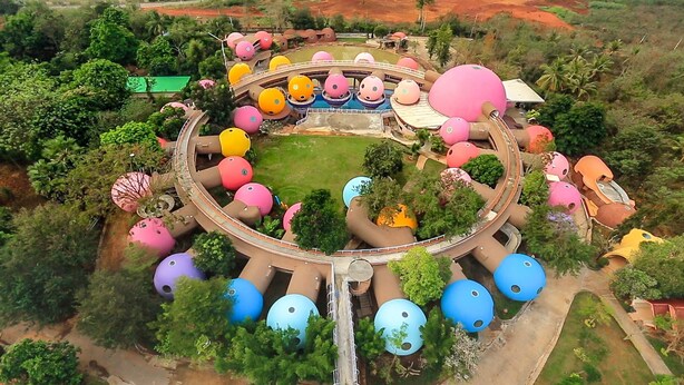 An aerial view of a park with a circular water slide surrounded by colorful spherical structures. - DNA Super Ozone Resort KhaoYai (Pak Chong)