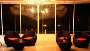 A modern lounge area with wicker furniture and a large decorative light fixture. - DNA Super Ozone Resort KhaoYai (Pak Chong)