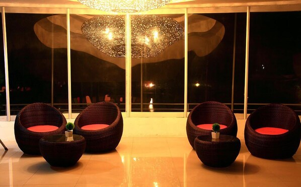 A modern lounge area with wicker furniture and a large decorative light fixture. - DNA Super Ozone Resort KhaoYai (Pak Chong)
