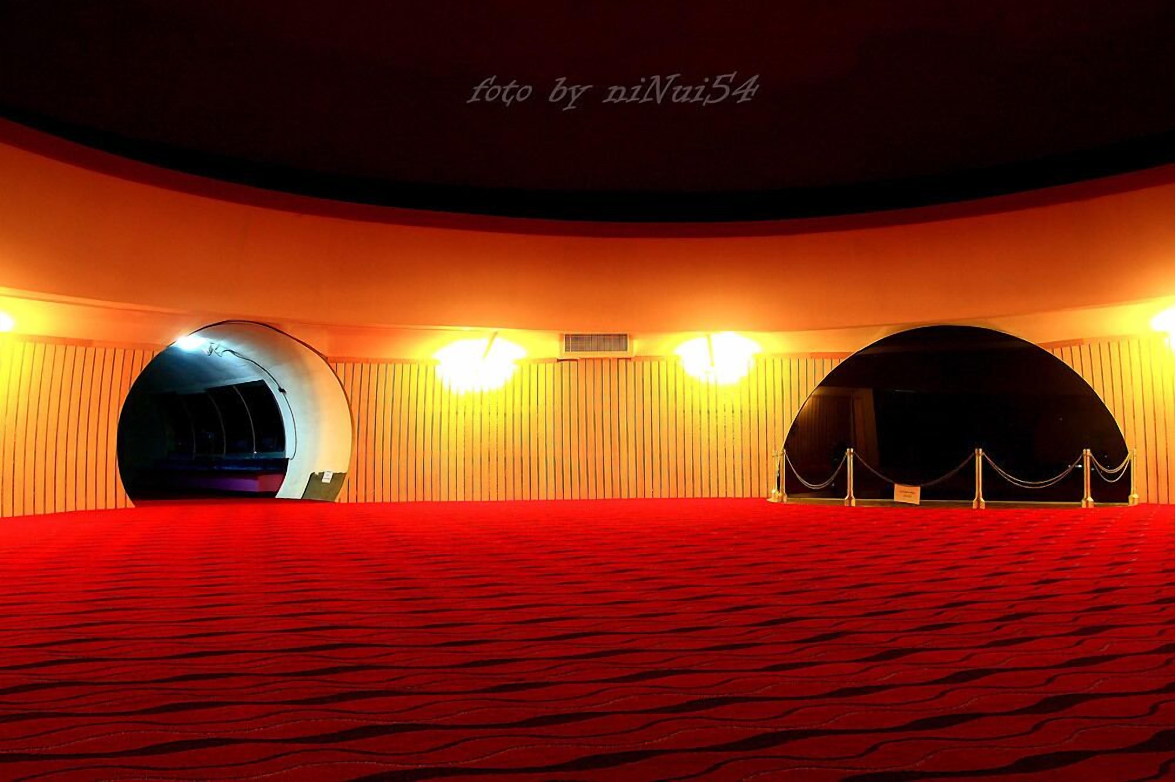 A theater with a red carpet and two large arched openings.