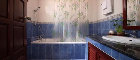 Un baño con bañera, lavabo y ducha.