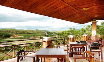 Una terraza de madera con mesas y sillas con vistas a un paisaje pintoresco.
