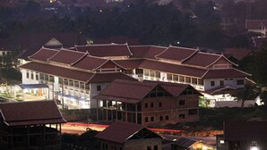 A large building with multiple levels and a traditional architectural style, featuring a prominent central structure with a balcony.