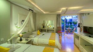 Quarto de hotel com duas camas, uma escrivaninha, televisão e varanda com vista para o jardim.