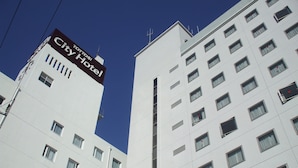 Un hotel con un llamativo letrero que dice City Hotel, varios pisos y un diseño arquitectónico moderno.