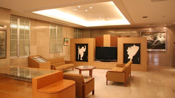 Una sala de estar moderna con un televisor de pantalla plana, asientos cómodos y obras de arte en las paredes.