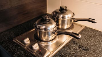 Une cuisine avec un fourneau et deux casseroles dessus.