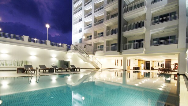 Una piscina con vista despejada del área de la piscina, incluyendo una escalera que lleva a los pisos superiores de un edificio.