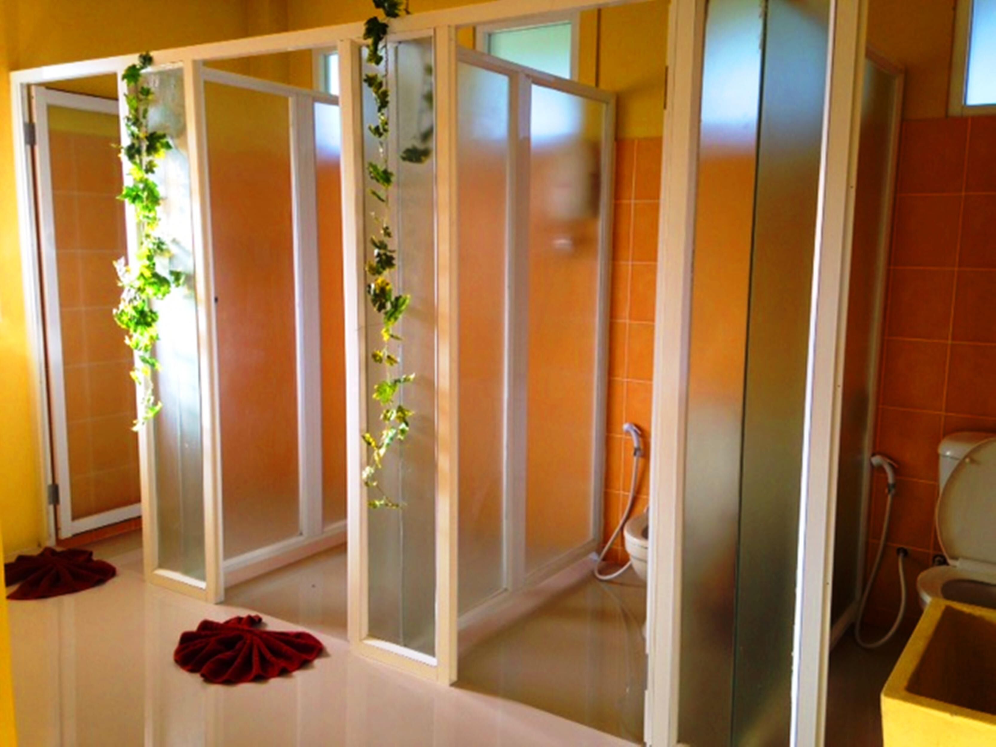 Een badkamer met een glazen scheiding, een douchegedeelte en een toilet.