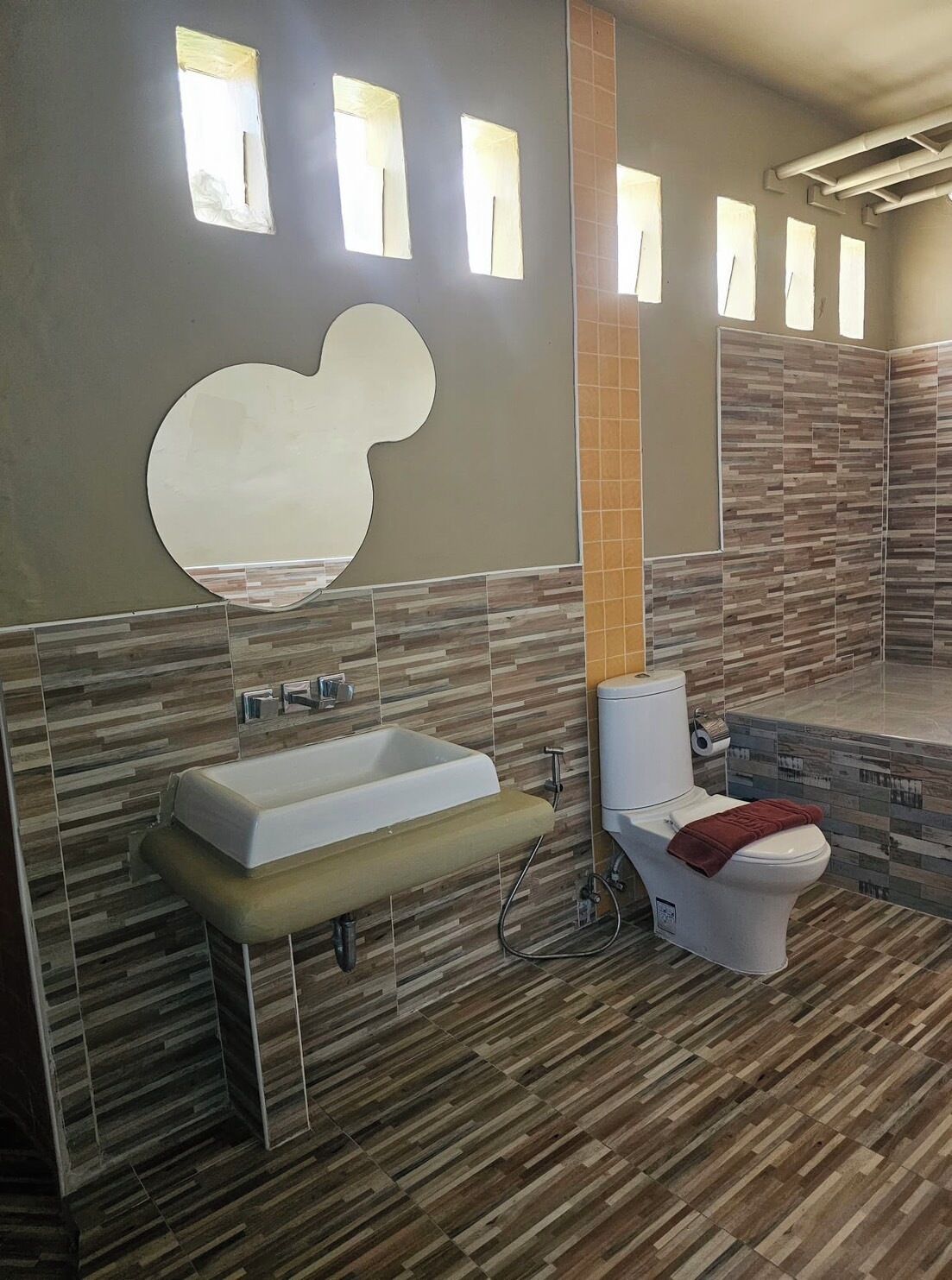 A modern bathroom with a large bathtub, a toilet, and a shower area.