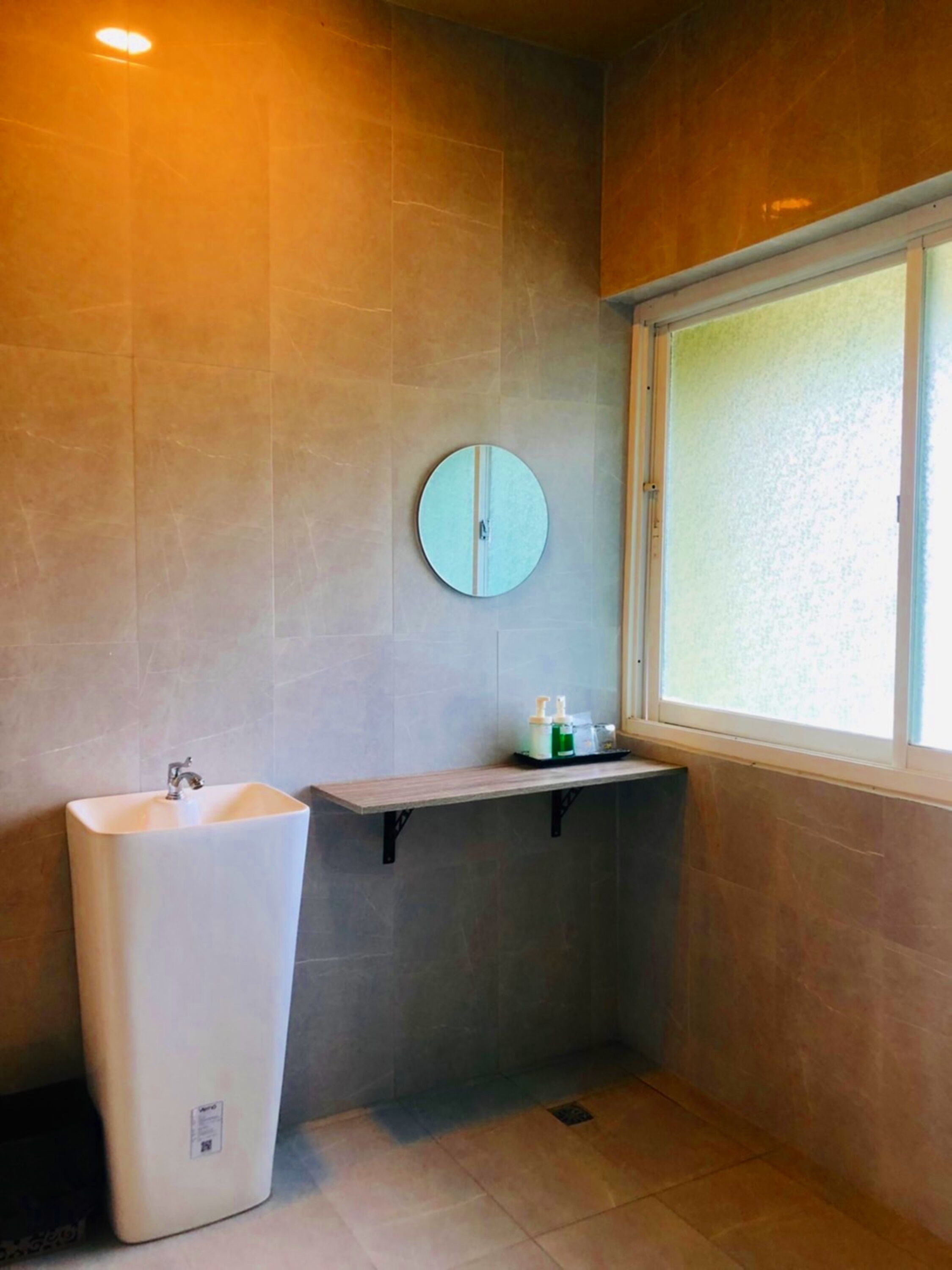 A bathroom with a large sink, a mirror, and a window.