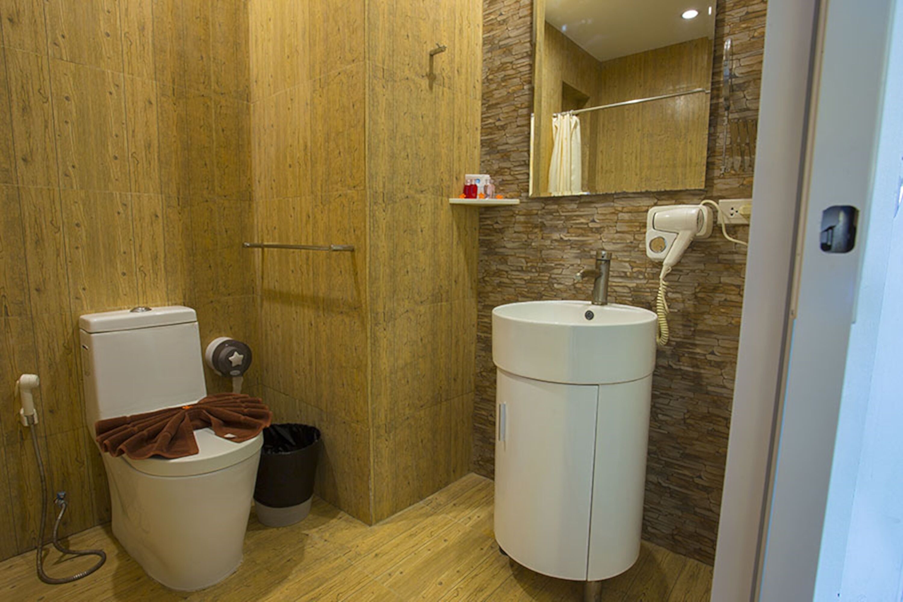 A bathroom with a toilet, sink, and mirror.