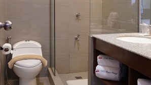 Un baño moderno con ducha envuelta en vidrio, inodoro y tocador con espejo.