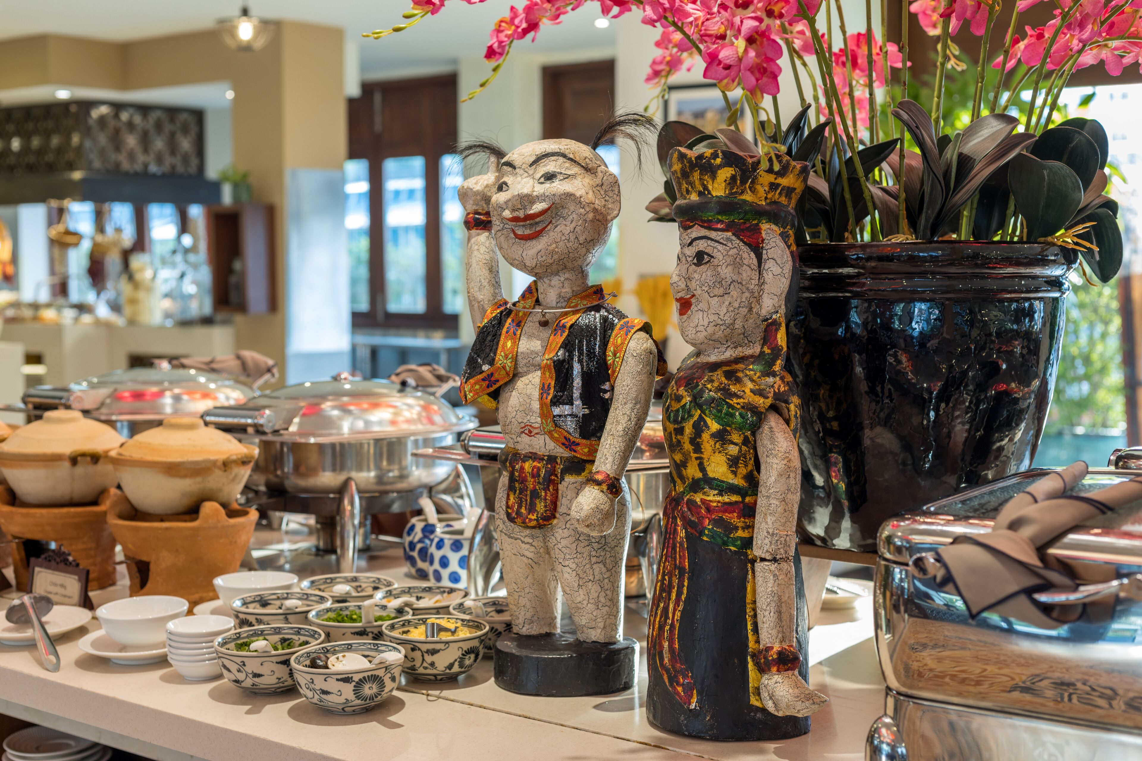 Un espace buffet proposant divers plats et agrémenté d’une statue décorative.