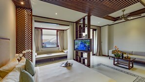 Ein Hotelzimmer mit einem großen Bett, einem Fernseher, einer Couch und einer dekorativen Wandverkleidung.