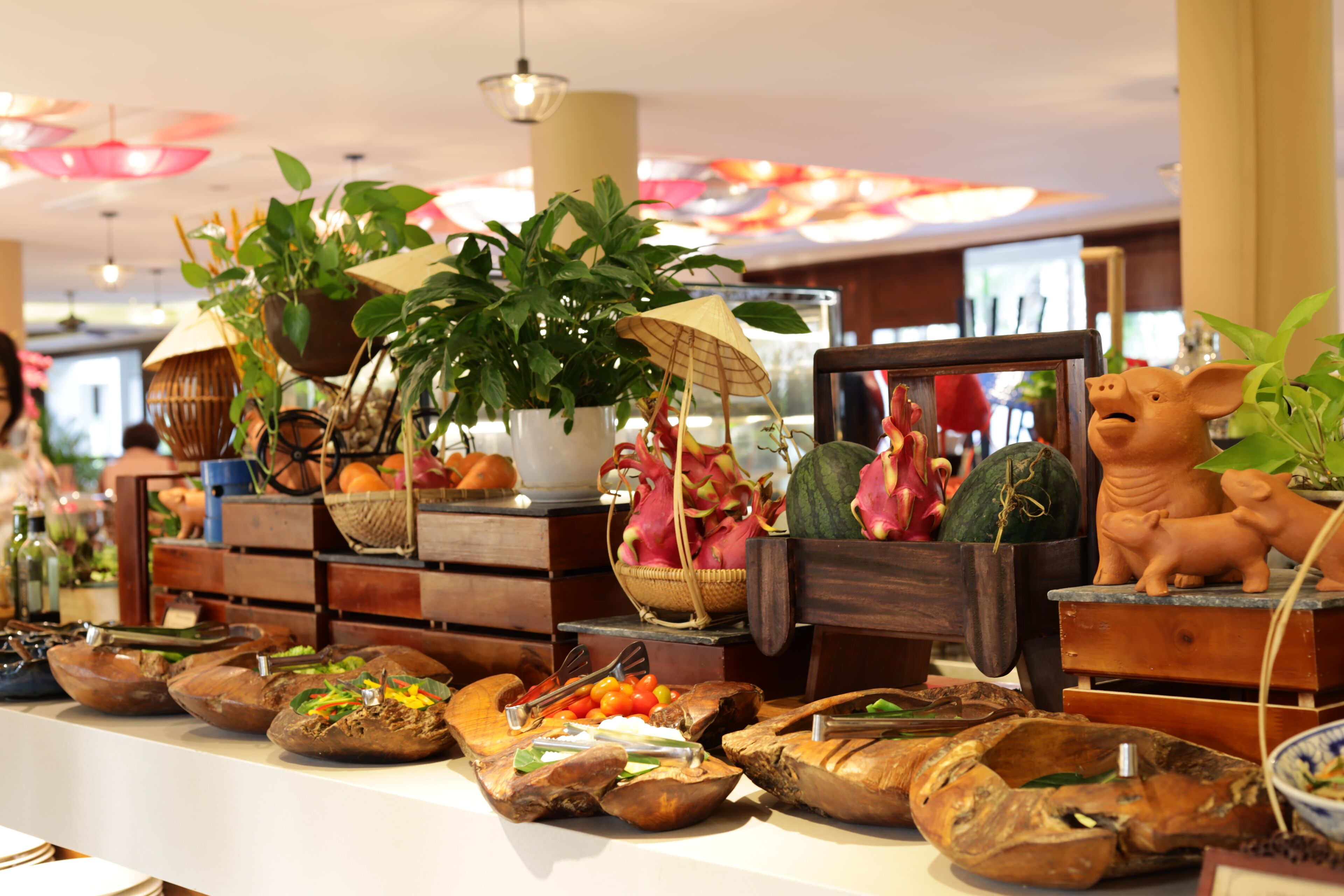 Una mesa de buffet con diversos platos y una estatua decorativa de un cerdo.