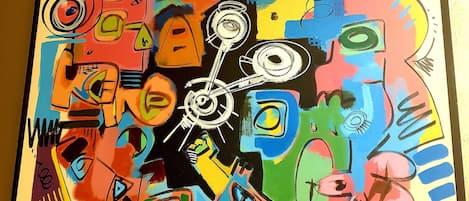Uma pintura abstrata e colorida com um design de relógio central, cercada por diversas formas e símbolos.