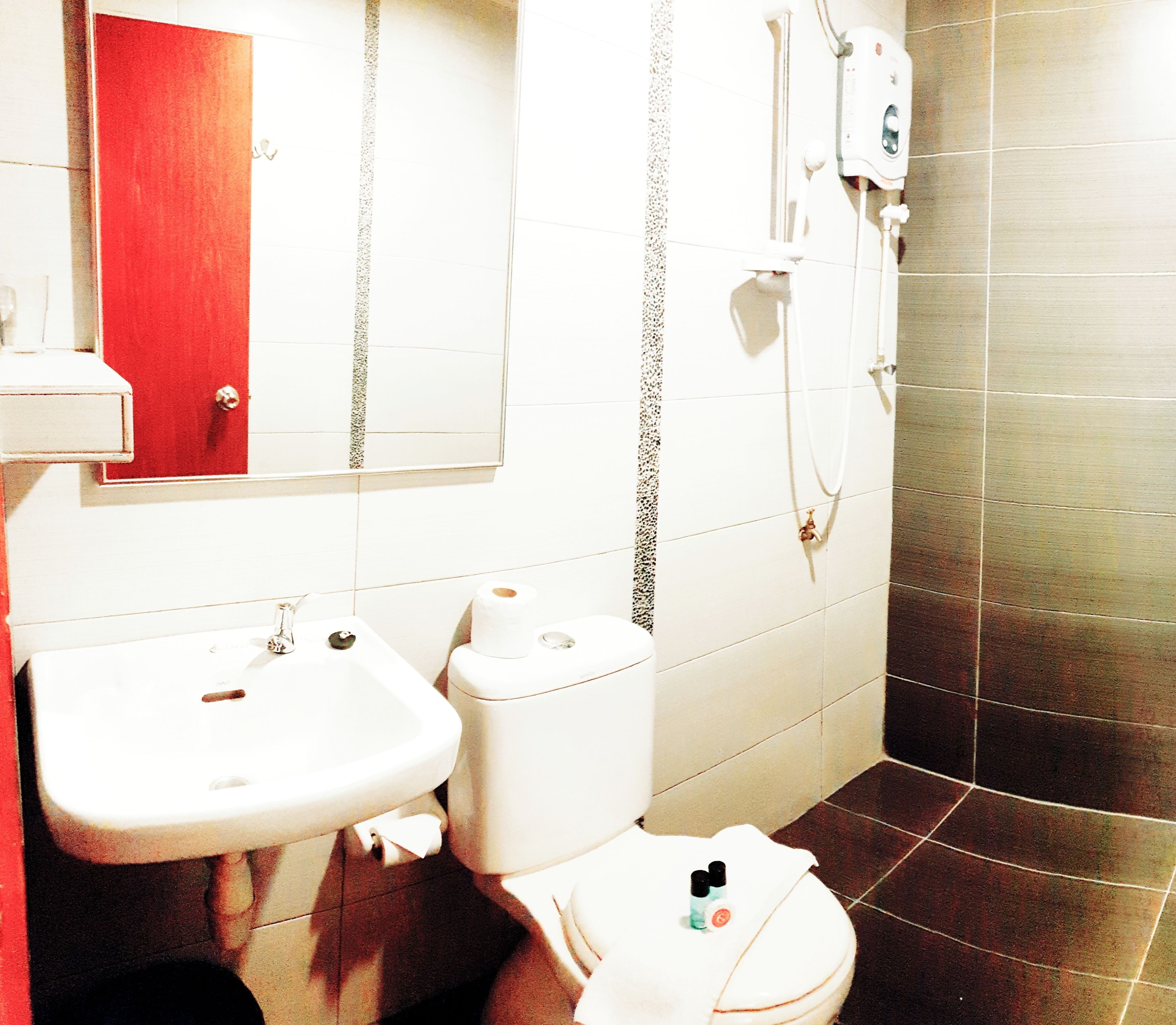 Un baño con lavamanos, inodoro y ducha.